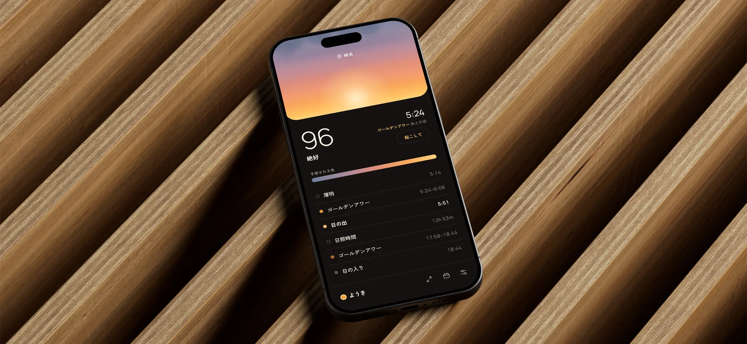 The Youki app on a phone, showing a sunrise quality score of 96 above a Japanese timeline of twilight, golden hour and sunrise times.