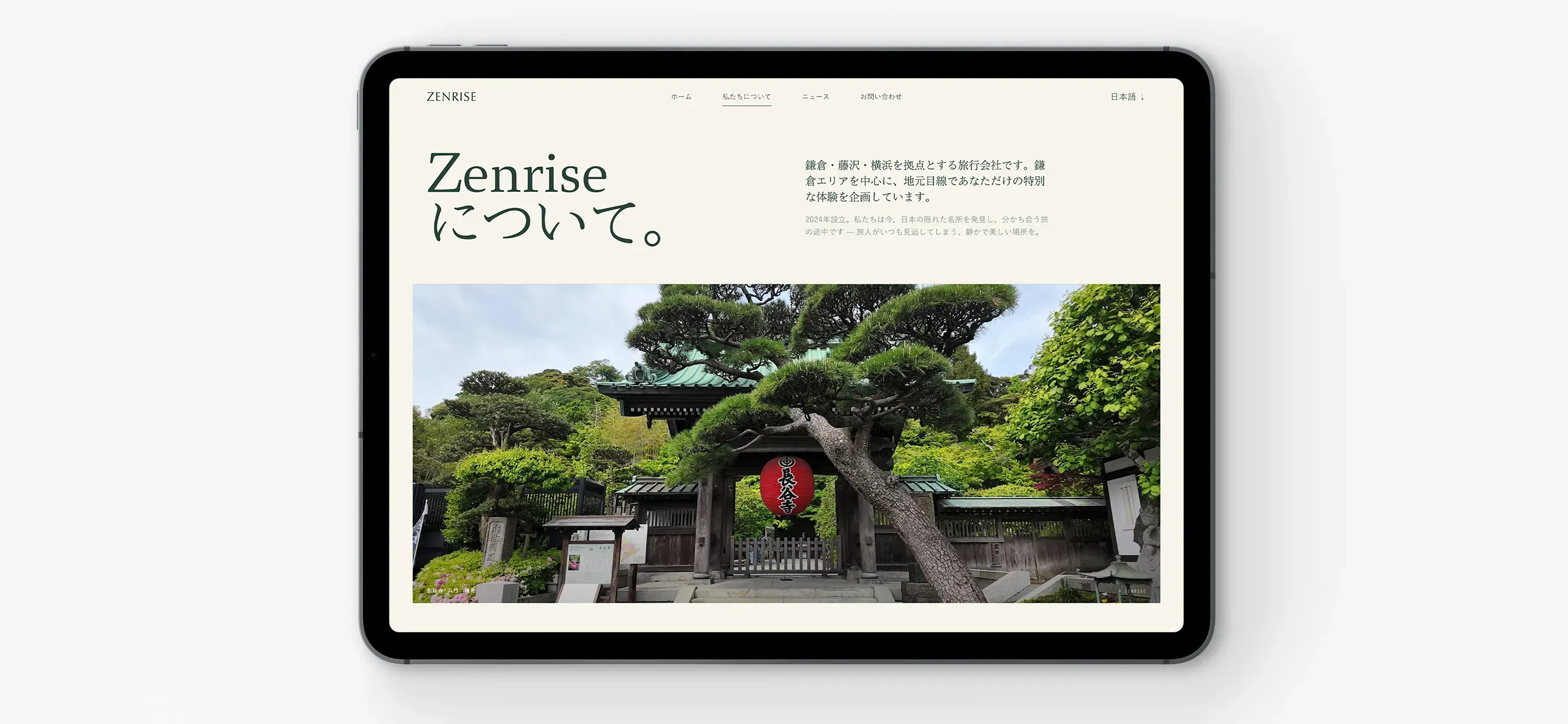 The Zenrise website's Japanese About page on a tablet, showing a templte gate framed by a pine tree.